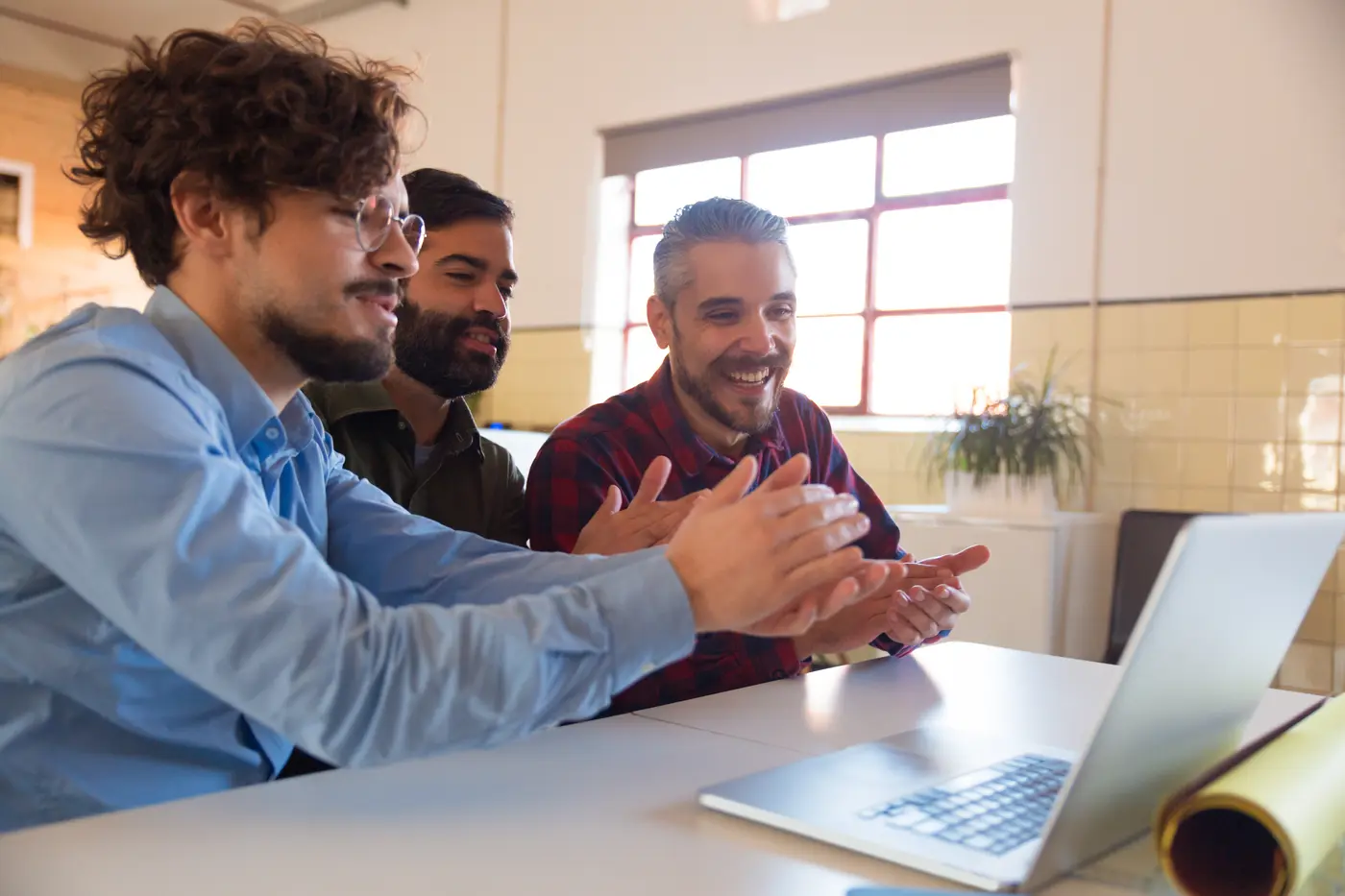Equipe reunida em torno de um notebook em um escritório